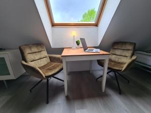 een bureau met 2 stoelen en een laptop. bij B1- Appartements in Bochum
