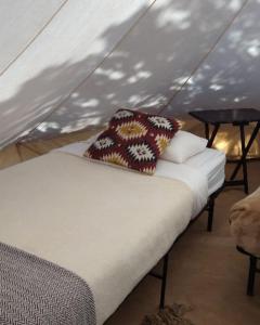 a bed in a tent with a pillow on it at Olympic Glamping in Port Angeles