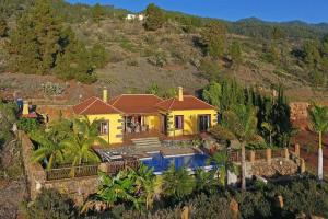 ein gelbes Haus auf einem Hügel mit Pool in der Unterkunft Ferienhaus für 4 Personen ca 120 qm in Tijarafe, La Palma Westküste von La Palma in Tijarafe