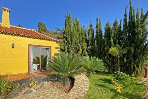 ein gelbes Haus mit einem Hof mit Palmen in der Unterkunft Ferienhaus für 4 Personen ca 120 qm in Tijarafe, La Palma Westküste von La Palma in Tijarafe