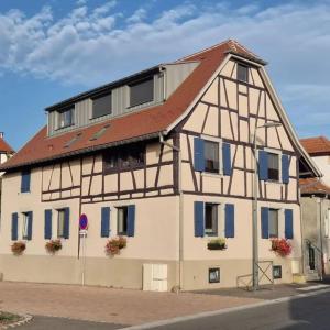 een huis met een rood dak en blauwe ramen bij Appartement 2 pièces tout confort, aux portes de Colmar in Andolsheim