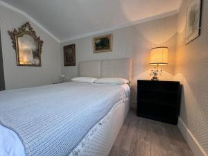 Un dormitorio con una gran cama blanca y una lámpara en ComeCasa La Magdeleine 2 Bedrooms Chalet, en La Magdeleine