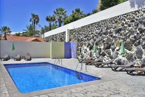 una piscina frente a una pared de piedra en Ferienhaus für 4 Personen ca 75 qm in Puerto Naos, La Palma Westküste von La Palma en Puerto Naos