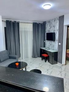 a living room with a couch and a desk with a television at بورتو سعيد شاليه غرفتين وصاله in `Ezbet Shalabi el-Rûdi
