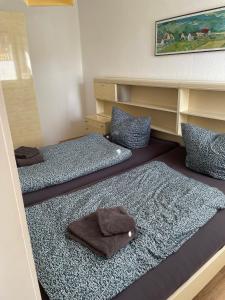 - une chambre avec 3 lits et des serviettes dans l'établissement Ferienhaus "Vogelnest", à Berumbur