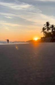 une personne pêchant sur la plage au coucher du soleil dans l'établissement Keona Beach, à La Libertad
