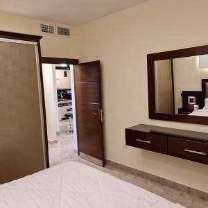 een slaapkamer met een dressoir en een spiegel aan de muur bij 30th apartment in Amman