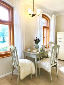 einem Esstisch mit 2 Stühlen und einem Tisch mit Blumen in der Unterkunft Landhaus Vogtland in Bad Elster