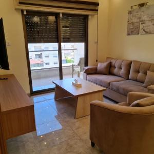salon z kanapą i stolikiem kawowym w obiekcie 30th apartment w mieście Amman