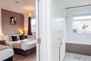a bedroom with two beds and a glass shower at Brays Home for families, contractors and professionals in Birmingham