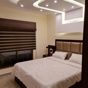 Un dormitorio con una cama grande y una ventana en 30th apartment, en Amán