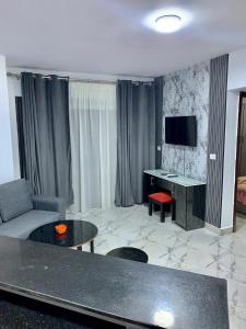 a living room with a couch and a table and a television at بورتو سعيد شاليه غرفتين وصاله in `Ezbet Shalabi el-Rûdi +21 photos
