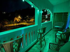 einen Balkon mit Stühlen und eine Bar in der Nacht in der Unterkunft Golden Dream Villas & Studio A/B Pool View in Isabela