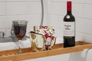 una botella de vino y una copa en un estante en City Centre Apartment with Free Parking, Super-Fast Wifi and Smart TV with Netflix by Yoko Property, en Milton Keynes