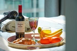 una botella de vino y un plato de fruta y una copa en City Centre Apartment with Free Parking, Super-Fast Wifi and Smart TV with Netflix by Yoko Property, en Milton Keynes
