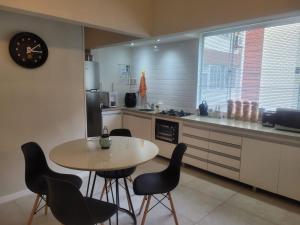 uma cozinha com mesa e cadeiras e um relógio em Apartamento em Ipanema no Rio de Janeiro