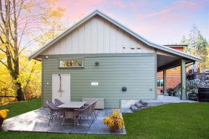 a green shed with a table and chairs in a yard at Cowichan Valley Guest Cottage in Ladysmith