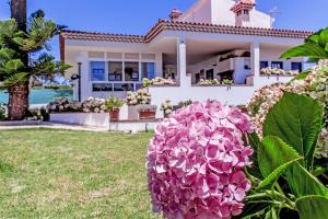 una casa con flores rosas delante de ella en Ferienhaus mit Privatpool für 8 Personen ca 500 qm in Santa Maria De Guia, Gran Canaria Nordküste Gran Canaria, en Santa María de Guía de Gran Canaria