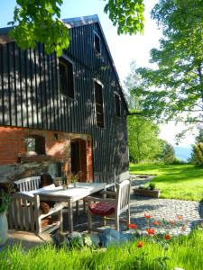 un patio con tavolo e sedie di fronte a un edificio di Berghütte Vogtland a Klingenthal