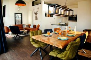 uma cozinha e sala de estar com uma mesa de madeira e cadeiras em Royale Cube mit Dachterrasse Meerblick und Strand em Hulshorst