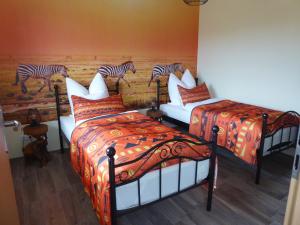 a room with two beds with zebras on the wall at Afrika in Eggesin