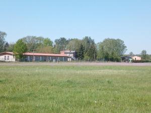 a field of grass with a building in the background at Afrika in Eggesin