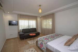 - une chambre avec un lit, une chaise et un canapé dans l'établissement Villa Meriem, Fès, à Oulad Tayeb