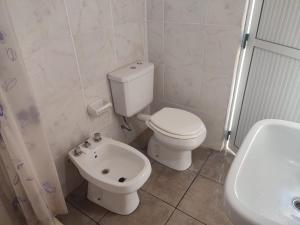 bagno bianco con servizi igienici e lavandino di Casa de Alquiler a Corrientes