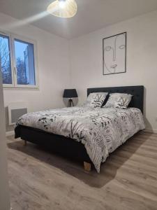 una camera da letto con un grande letto in una stanza bianca di La Maison de Coco a Le Puy