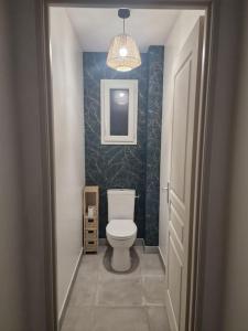 a bathroom with a white toilet in a hallway at La Maison de Coco in Le Puy