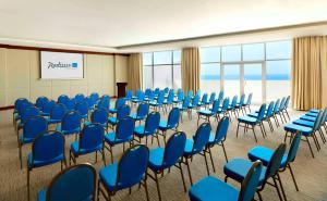 a conference room with blue chairs and a podium at Radisson Blu Resort, Fujairah in Dibba