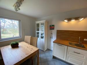 Pruchten的住宿－Ferienhaus Boddenblick mit Sauna，厨房配有木桌和水槽。