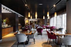 una sala da pranzo con tavoli e sedie in un ristorante di Radisson Blu Hotel Milan a Milano