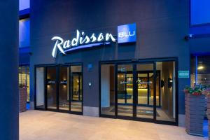 ein Gebäude mit einem Schild an der Seite in der Unterkunft Radisson Blu Hotel Milan in Mailand