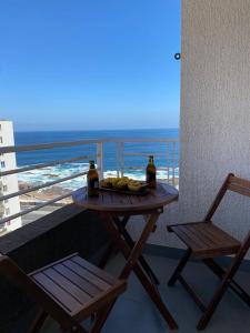 una mesa y 2 sillas en un balcón con vistas al océano en Dpto excelente ubicación con estacionamiento incluido, en Antofagasta