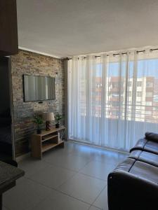 a living room with a couch and a flat screen tv at Dpto excelente ubicación con estacionamiento incluido in Antofagasta