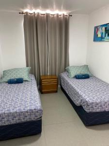 a bedroom with two beds and a window at Dpto excelente ubicación con estacionamiento incluido in Antofagasta