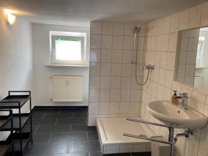 een witte badkamer met een wastafel en een douche bij Ferienapartment Dörfles-Esbach in Dörfles