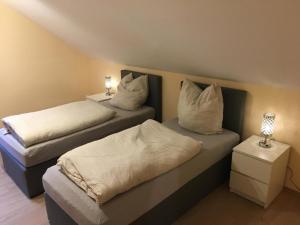 dwa łóżka w pokoju z dwoma lampami w obiekcie Ferienwohnung Adlerhorst w mieście Lautertal
