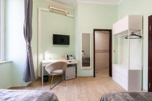 a bedroom with a desk and a bed and a mirror at CARLO ALBERTO GUESTHOUSE - close to CENTRAL STATION in Rome