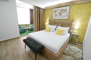 una camera da letto con un grande letto bianco con cuscini gialli di PIAZZA ROOMS Zadar a Zara (Zadar)