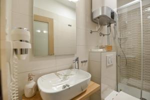 bagno bianco con lavandino e doccia di PIAZZA ROOMS Zadar a Zara (Zadar)