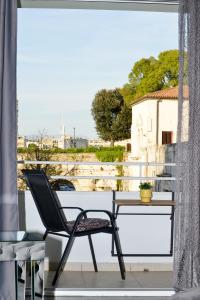 a table and chair on a balcony with a view at PIAZZA ROOMS Zadar in Zadar