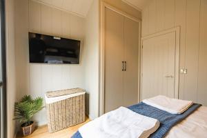 a bedroom with a bed and a flat screen tv at Lowfield Lodge & Hot Tub - Humberston Fitties Beach in Cleethorpes