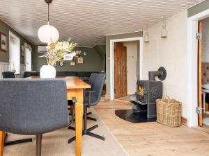 sala de estar con mesa y estufa de leña en 6 person holiday home in Harbo re en Harboør