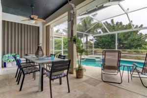 a dining room with a table and chairs and a pool at Coastal Haven in Apollo Beach