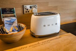 a toaster on a counter next to a bowl of food at Lowfield Lodge & Hot Tub - Humberston Fitties Beach in Cleethorpes