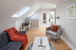 - un salon avec un canapé et deux chaises dans l'établissement Stylish One bedroom Flat near Kingsbury Station, à Wealdstone