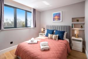 a bedroom with a bed with two towels on it at Stylish One bedroom Flat near Kingsbury Station in Wealdstone
