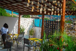 un patio avec des tables et des chaises sous une pergola dans l'établissement Hotel Xinte na casa, à Tarrafal